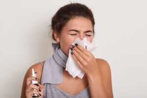 ill-allergic-woman-blowing-running-nose-having-got-flu-catch-cold-sneezing-handkerchief-posing-with-closed-eyes-isolated-white-holding-nasal-spray-hand